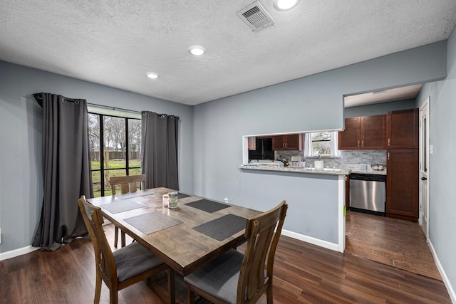 dining space featuring dark hardwood / wood-style floors and a textured ceiling