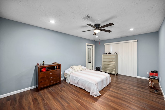 bedroom featuring ceiling fan, dark hardwood / wood-style floors, and a textured ceiling