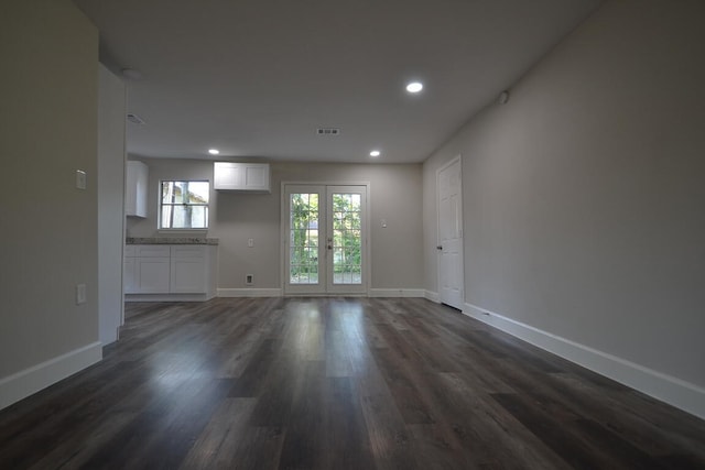 unfurnished living room featuring french doors and dark hardwood / wood-style flooring