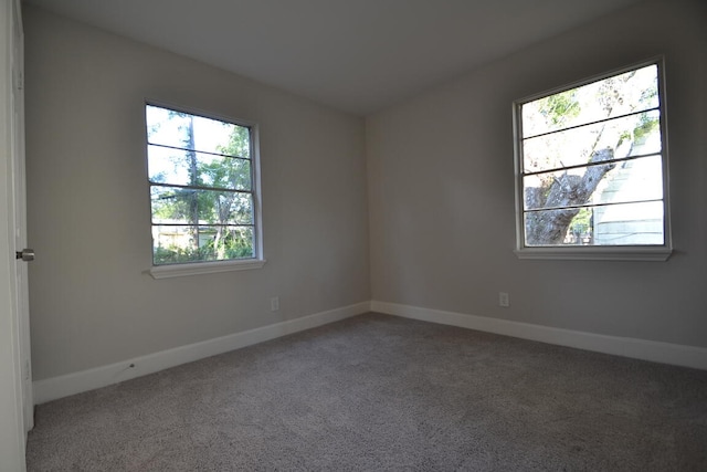 spare room with dark colored carpet