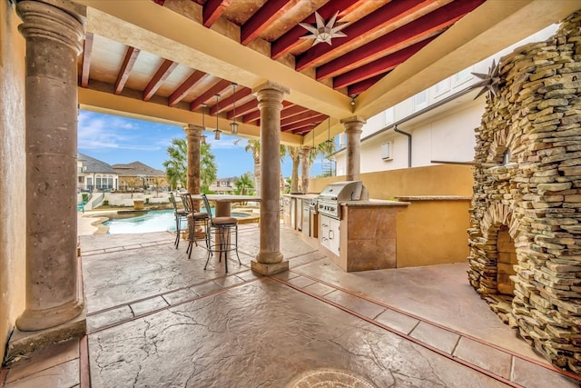 view of patio with an outdoor kitchen and a grill