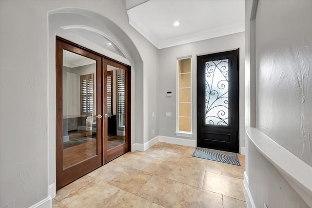 foyer featuring a healthy amount of sunlight, crown molding, and french doors