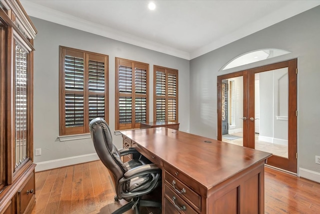 office with crown molding, light hardwood / wood-style floors, and french doors