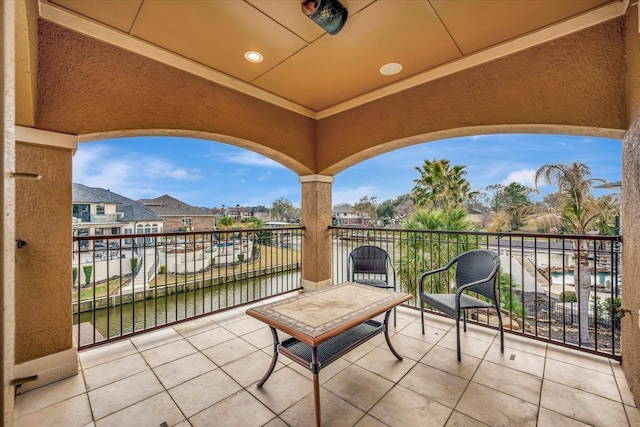 view of patio / terrace with a water view and a balcony