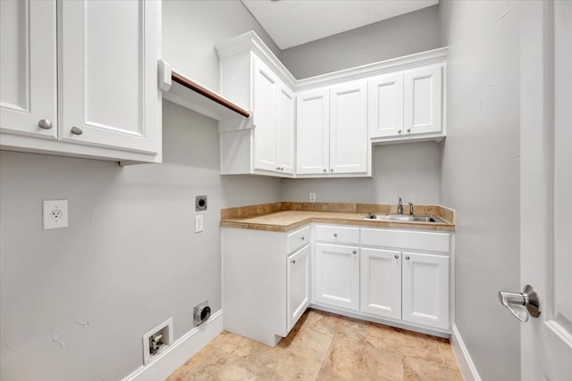 clothes washing area with cabinets, hookup for an electric dryer, and sink