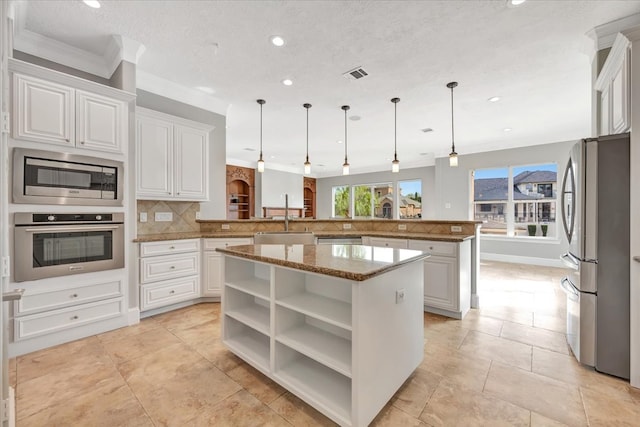 kitchen with kitchen peninsula, a kitchen island, stainless steel appliances, and white cabinets