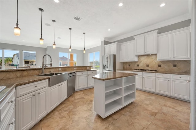 kitchen featuring pendant lighting, a wealth of natural light, white cabinetry, and appliances with stainless steel finishes