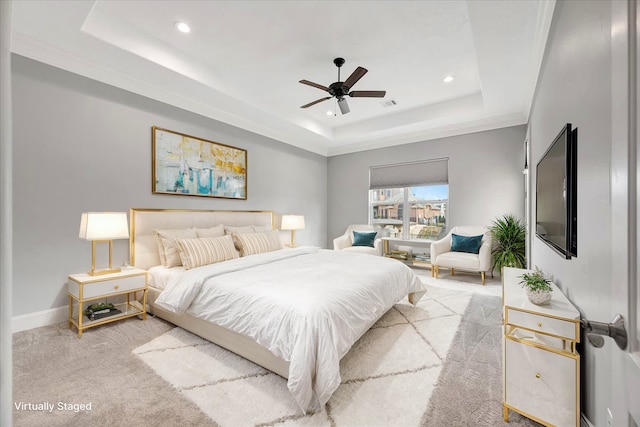 carpeted bedroom with ceiling fan, a raised ceiling, and crown molding