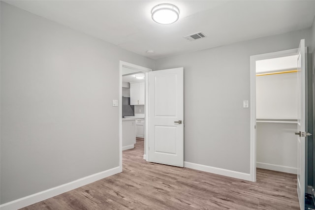 unfurnished bedroom featuring a closet and light wood-type flooring