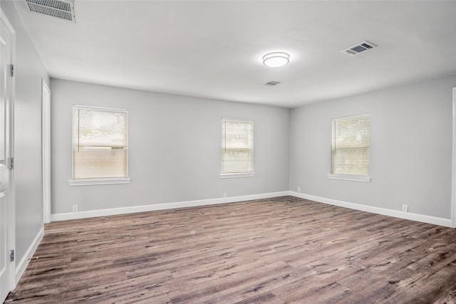 spare room with wood-type flooring and a wealth of natural light