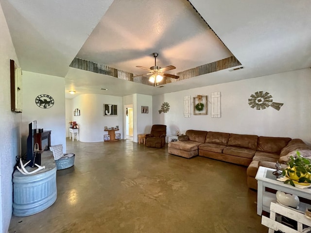 living room featuring ceiling fan and a tray ceiling