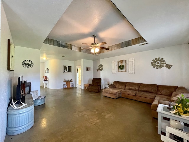 living room with ceiling fan and a tray ceiling