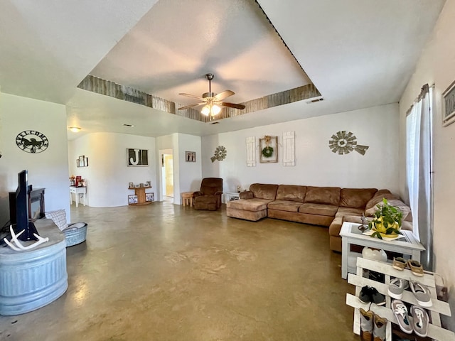 living room featuring ceiling fan and a tray ceiling