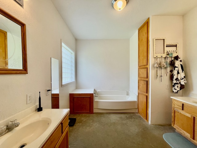 bathroom featuring concrete flooring, a bathing tub, and vanity