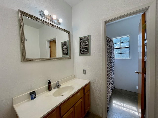 bathroom with toilet, tile flooring, and vanity