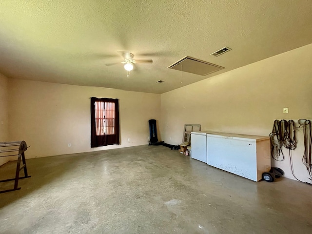 interior space with ceiling fan, a textured ceiling, and concrete flooring