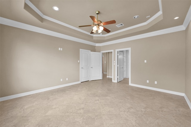 empty room featuring crown molding, a tray ceiling, and ceiling fan