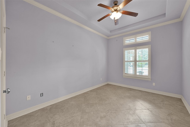 spare room with ornamental molding, a tray ceiling, and ceiling fan