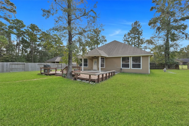 rear view of property featuring a wooden deck and a lawn