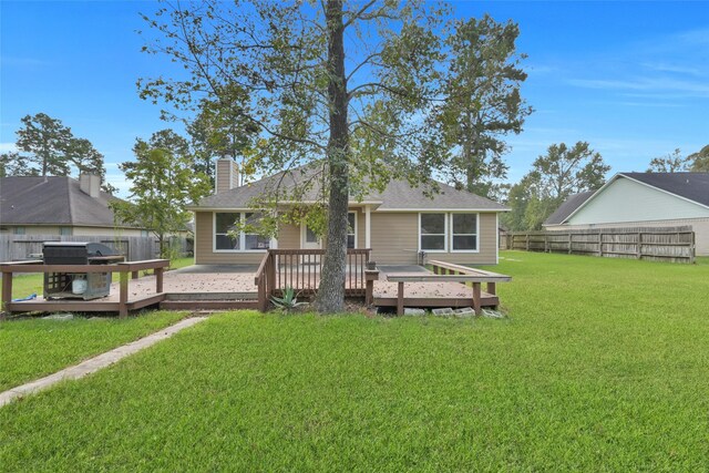 rear view of house featuring a yard and a wooden deck