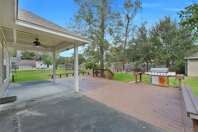 wooden terrace featuring a patio area, area for grilling, a yard, and ceiling fan