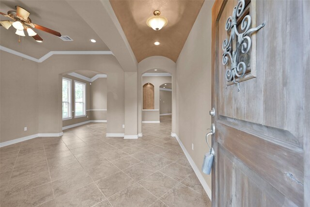 foyer entrance featuring ornamental molding, ceiling fan, and vaulted ceiling