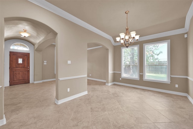 foyer entrance featuring ornamental molding, a chandelier, and vaulted ceiling