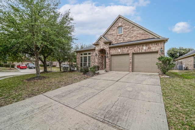 view of front facade with a front yard, a garage, and central AC unit