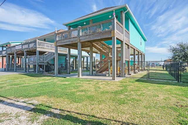 back of property with a wooden deck and a lawn