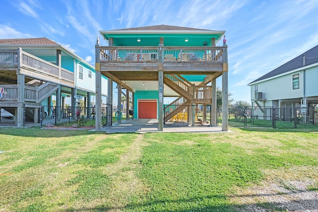 back of house featuring a wooden deck, a patio, and a lawn