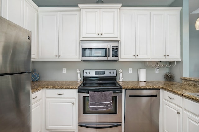 kitchen featuring white cabinetry, dark stone countertops, and stainless steel appliances