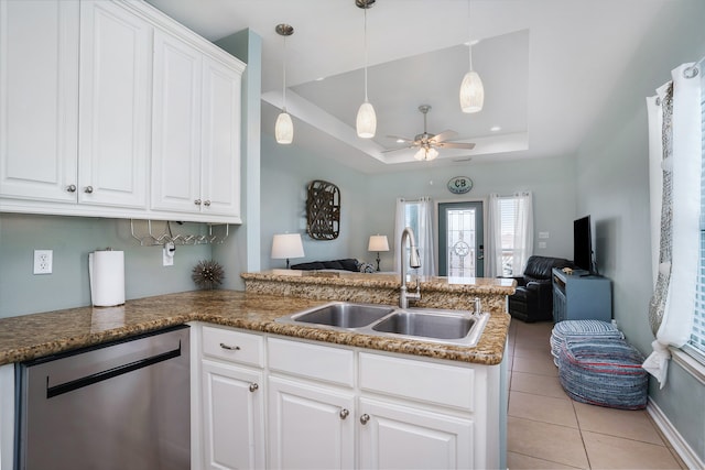 kitchen featuring sink, ceiling fan, a raised ceiling, dishwasher, and white cabinetry