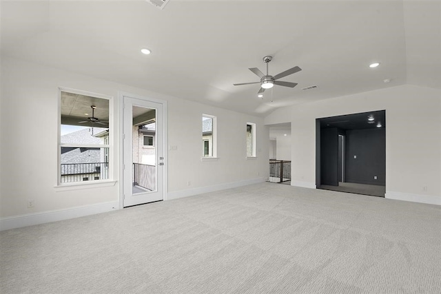 unfurnished living room featuring ceiling fan, vaulted ceiling, and light colored carpet