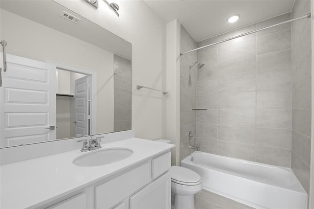 full bathroom featuring vanity, toilet, and tiled shower / bath