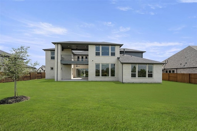 back of house featuring a patio, a lawn, and a balcony