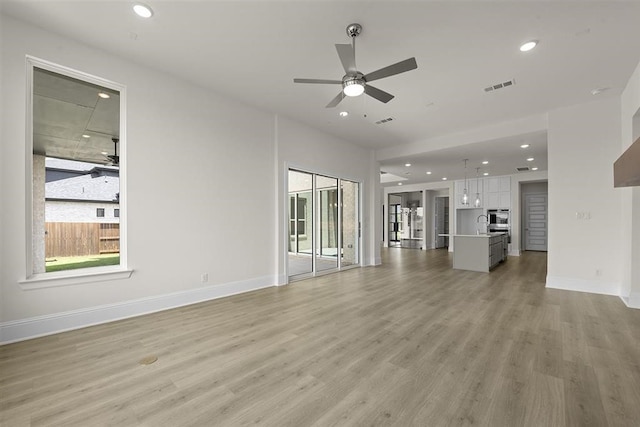 unfurnished living room featuring light hardwood / wood-style flooring and ceiling fan