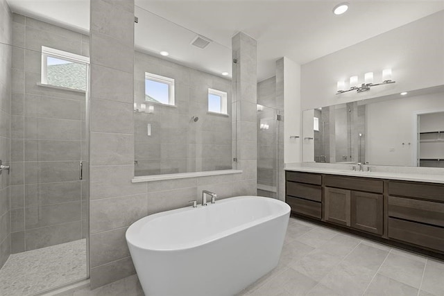 bathroom with vanity, tile patterned floors, independent shower and bath, and tile walls