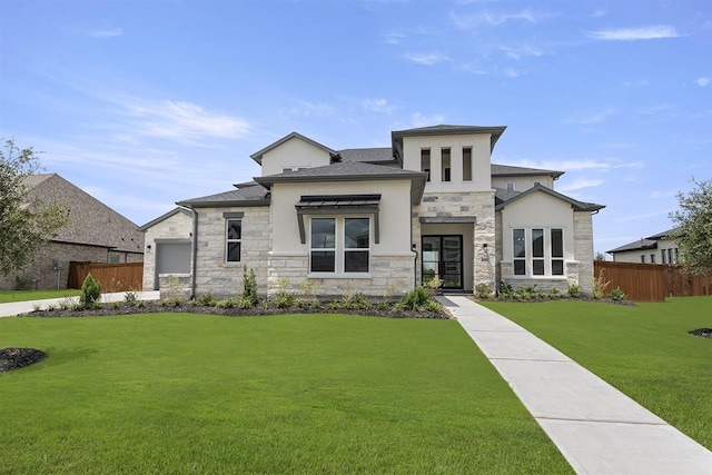 prairie-style home featuring stone siding, a front yard, and fence