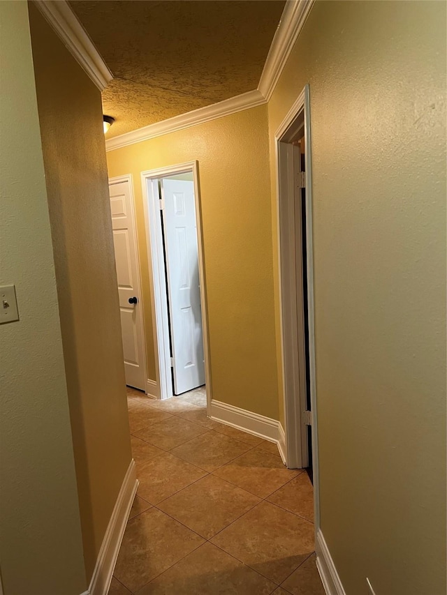 corridor featuring light tile patterned floors and ornamental molding