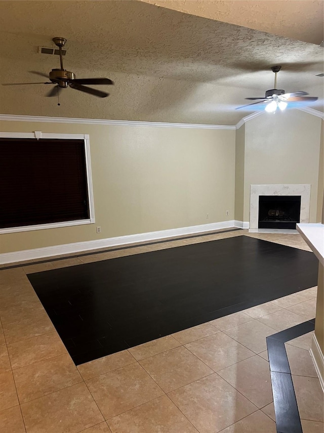 unfurnished living room with a fireplace, light tile patterned floors, a textured ceiling, and crown molding