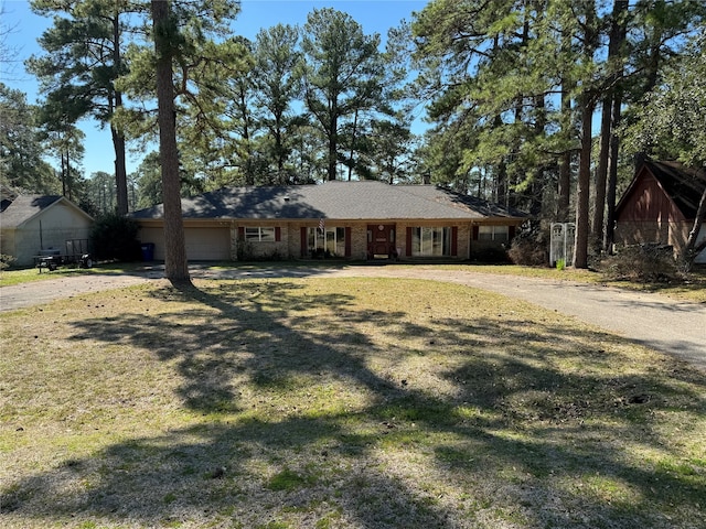 ranch-style house featuring a front yard and a garage