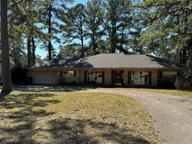 ranch-style home with a front lawn and a garage