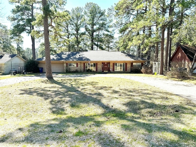 ranch-style house featuring a garage and a front yard