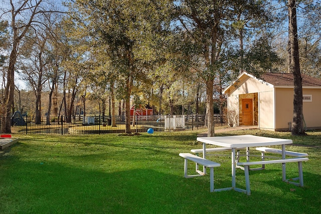 view of property's community with a playground, an outdoor structure, and a yard