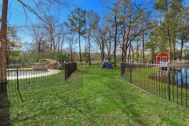 view of yard featuring a water view, a shed, and a fenced in pool