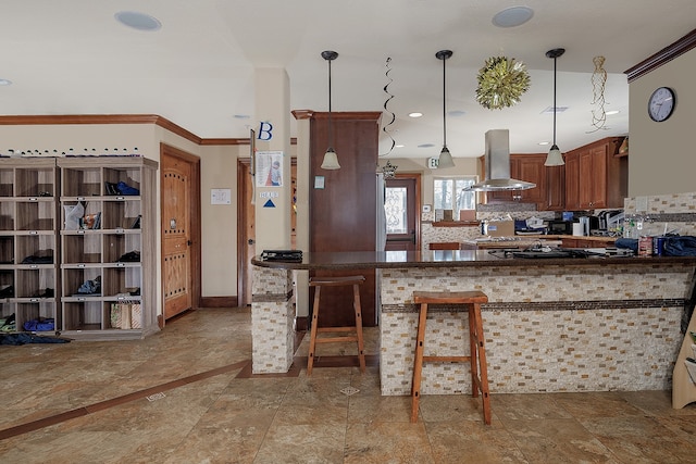 kitchen featuring pendant lighting, tasteful backsplash, ventilation hood, kitchen peninsula, and ornamental molding