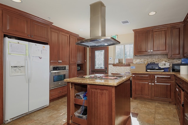 kitchen featuring island range hood, oven, a center island, white fridge with ice dispenser, and cooktop