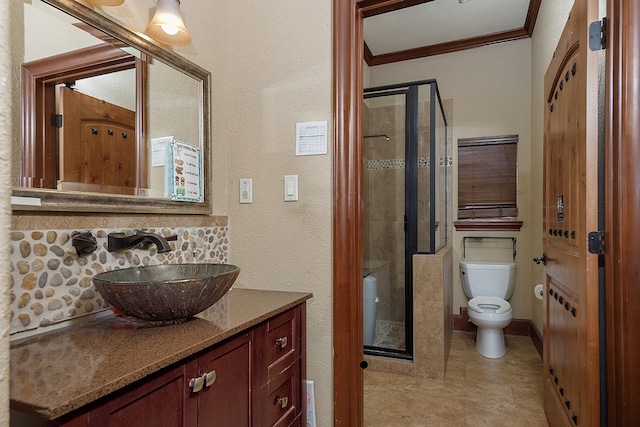 bathroom with crown molding, a shower with shower door, vanity, and toilet