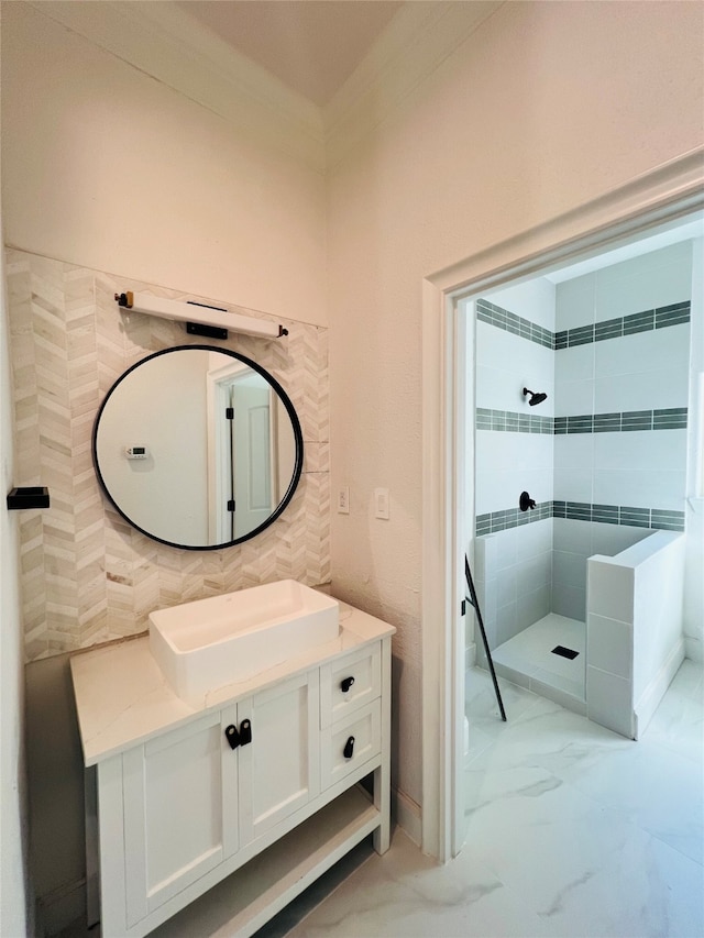 bathroom featuring tiled shower and vanity