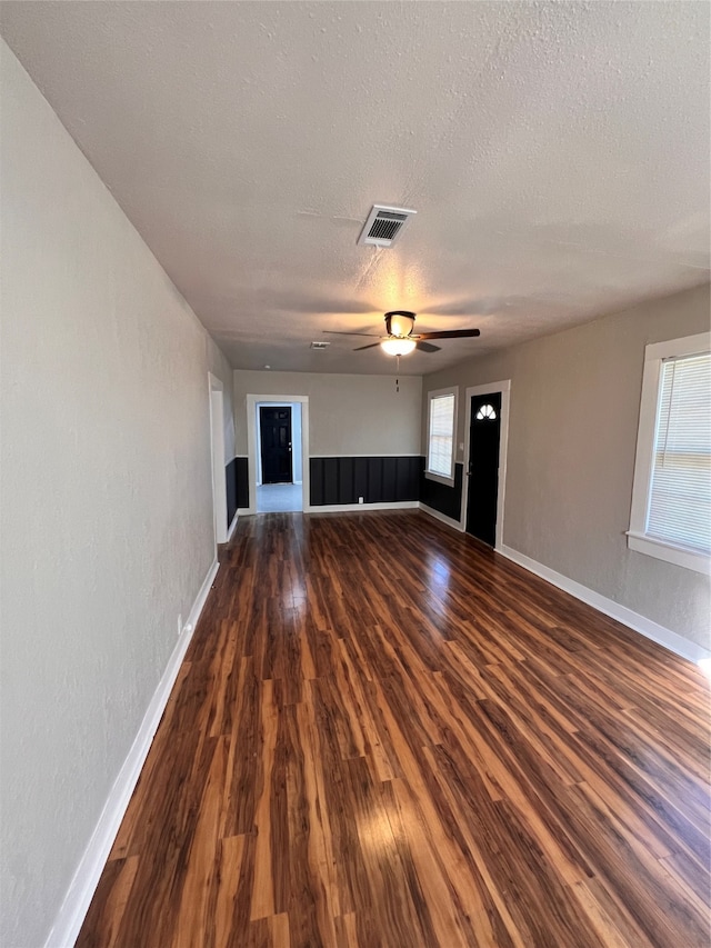 spare room with ceiling fan, dark wood-type flooring, and a textured ceiling